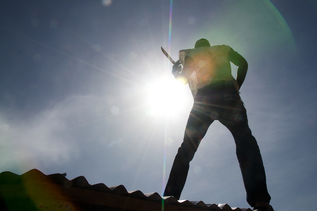 Chief Carpenter Pa Demba silhouetted by a sunburst